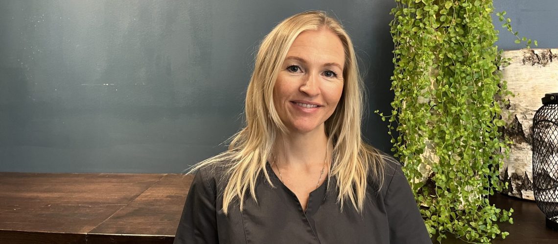 Bilde viser smilende Elisabet med lyst hår som jobber som hud og fotpleierhos Ahead Frisør og Velvære